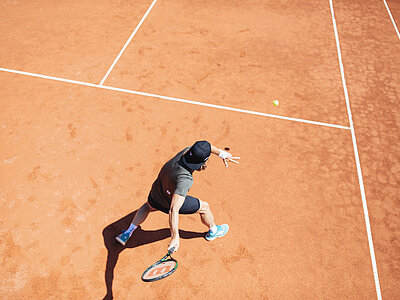 Mann beim Tennisspielen auf dem Tennisplatz im Hotel Truyenhof in Tirol